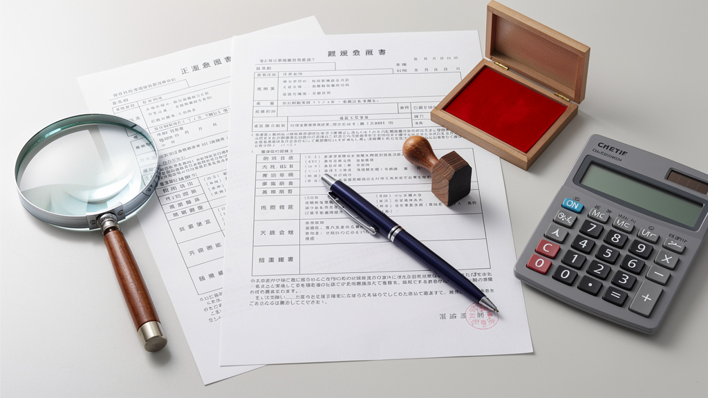 机に置かれた書類に印鑑でサインするイラスト